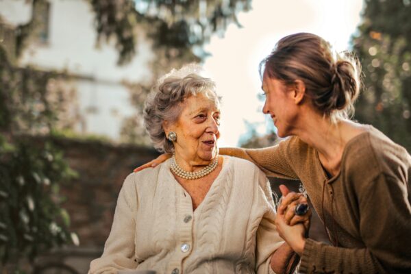 A young woman is showing kindness towards an old lady.