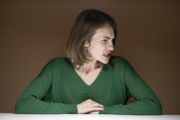 The woman is showing frustration or anger reaction.