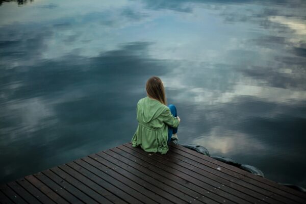 A woman is seated on the roof and there is a dark atmosphere.