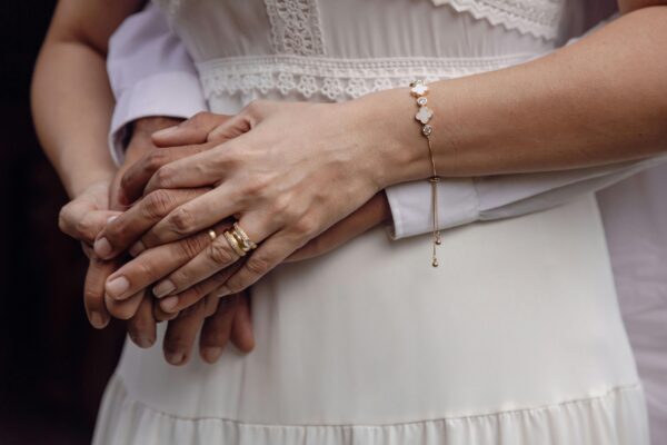 A woman holds the hand of another friend.